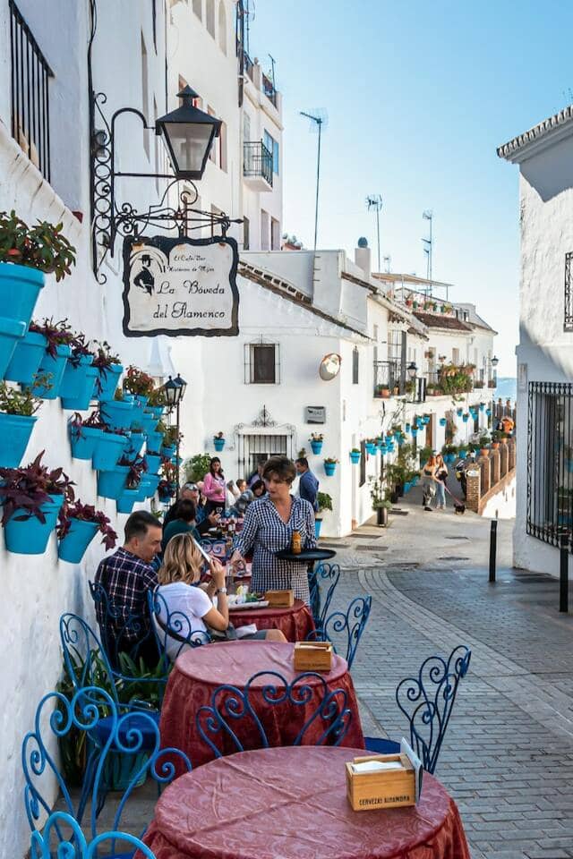 tables outside of restaurant in quiet street in Spain