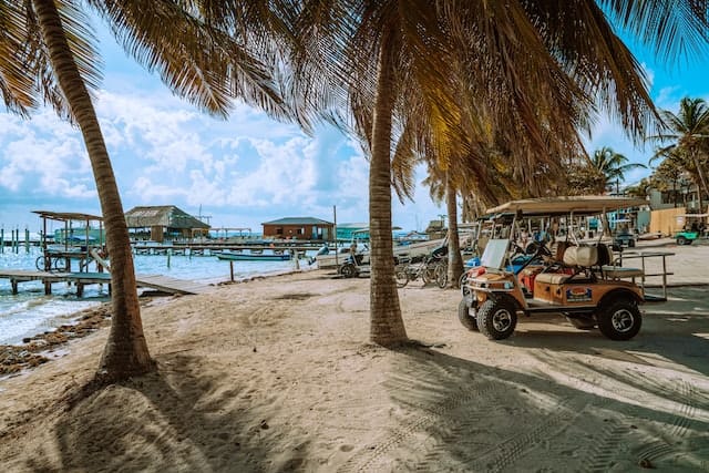 Golf carts parked near waters in Ambergris Caye, Belize